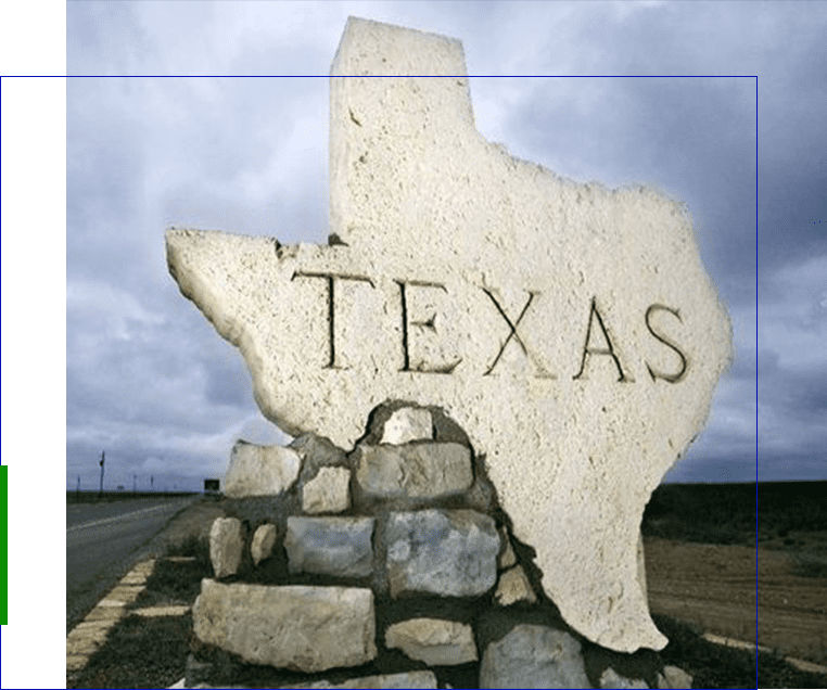 A large stone texas sign on the side of a road.